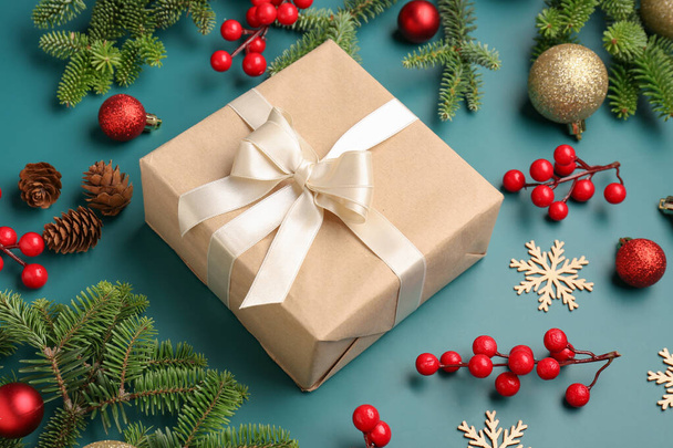 branches de sapin de Noël avec boîte cadeau, boules et rowan sur fond bleu - Photo, image