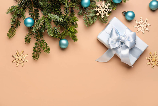 Karácsonyfa ágak ajándék doboz, labdák és dekorációk bézs háttér - Fotó, kép