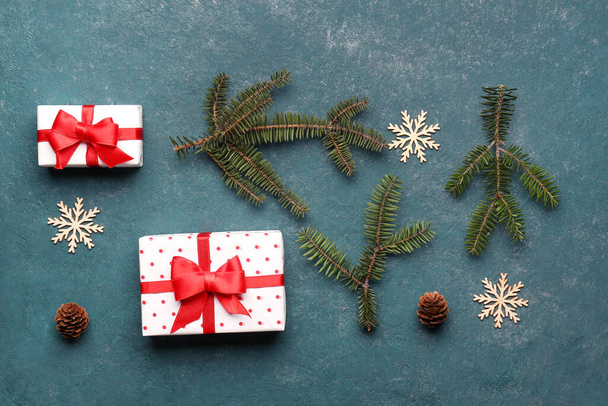 Ramas de árboles de Navidad con cajas de regalo, decoraciones y conos sobre fondo azul grunge - Foto, imagen