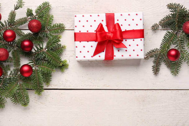 Kerst boom takken met geschenkdoos en ballen op witte houten achtergrond - Foto, afbeelding