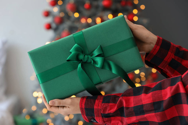 Femme donnant boîte cadeau à la maison la veille de Noël, gros plan - Photo, image