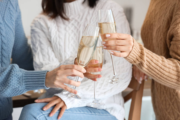 Young women with champagne celebrating Christmas in kitchen, closeup - Photo, Image