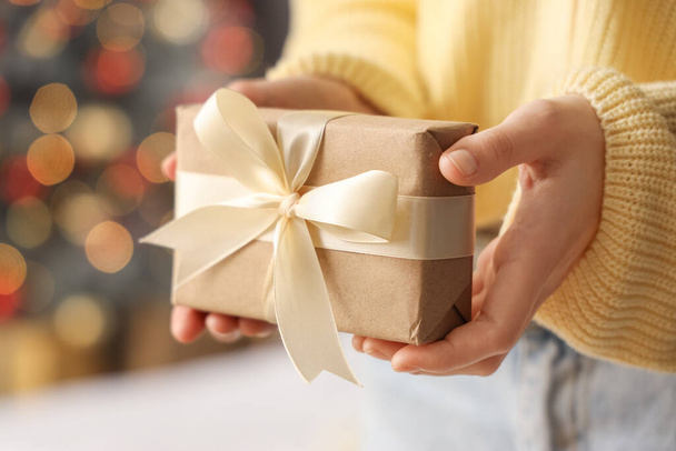 Γυναίκα κρατώντας κουτί δώρου στο σπίτι την παραμονή των Χριστουγέννων, closeup - Φωτογραφία, εικόνα