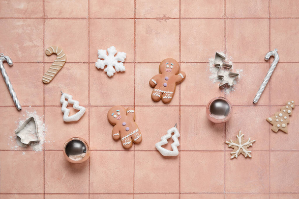 Σύνθεση με νόστιμα χριστουγεννιάτικα μπισκότα, διακοσμήσεις και κόφτες σε φόντο πλακιδίων - Φωτογραφία, εικόνα