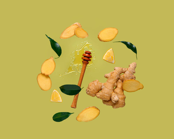 Fliegende Scheiben frischer Ingwerwurzel und Pfeffer mit Honig auf grünem Hintergrund - Foto, Bild