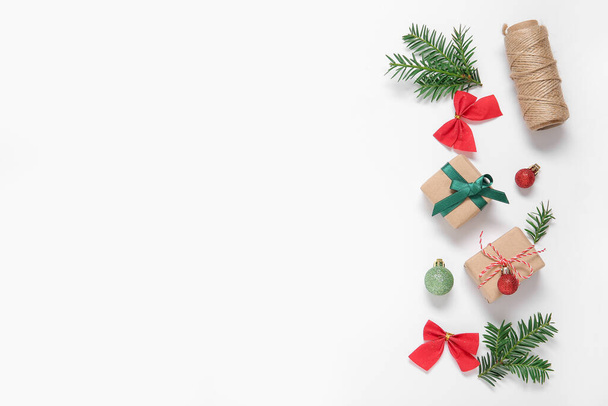 Touw, geschenkdozen, sparren takken en kerstversiering op witte achtergrond - Foto, afbeelding