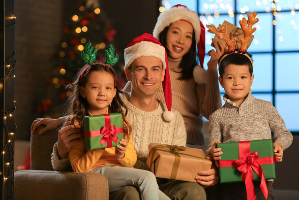 Familia feliz con regalos en casa en Nochebuena - Foto, imagen