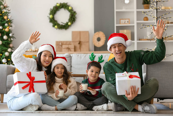 Familia feliz con regalos en casa en Nochebuena - Foto, Imagen