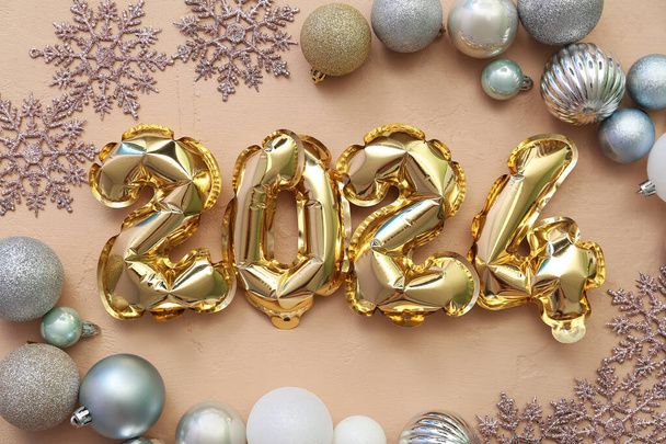 Composition avec figure 2024 faite de ballons en aluminium et décorations de Noël sur fond beige - Photo, image
