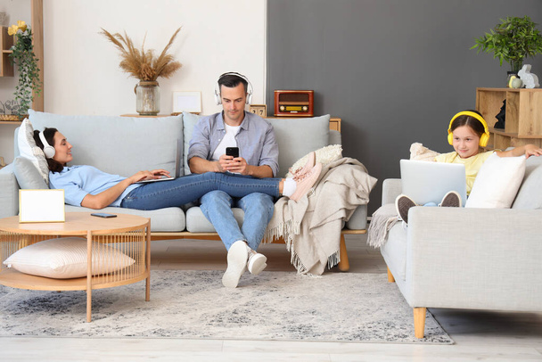 Šťastná rodina s gadgets odpočinku v obývacím pokoji - Fotografie, Obrázek