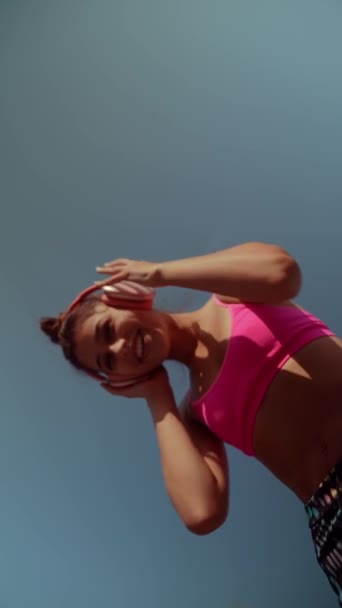 A stunning, young lady in colorful sportswear is performing warm-up exercises on the city streets. High quality 4k footage - Footage, Video