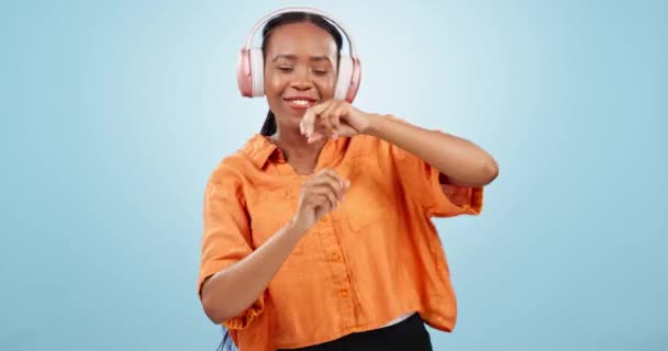 Dance, black woman and music headphones in studio for celebration of freedom, party and hearing audio song on blue background. Happy model listening to multimedia, disco sound and radio subscription. - Footage, Video