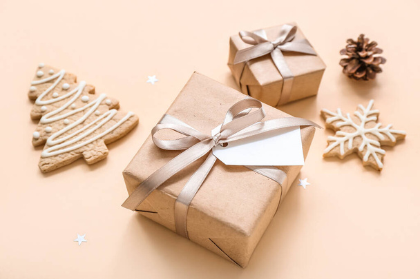 Χριστουγεννιάτικα κουτιά δώρων και μπισκότα σε μπεζ φόντο - Φωτογραφία, εικόνα