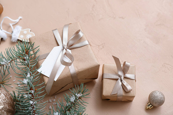Karácsonyfa ágak és ajándékdobozok bézs háttér - Fotó, kép