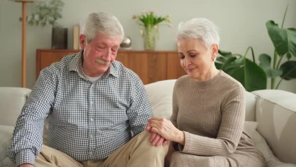 Senior adult mature couple in love holding hands at home. Mid age old husband and wife looking with tenderness love enjoying wellbeing. Grandmother grandfather together. Family moment love and care - Кадри, відео
