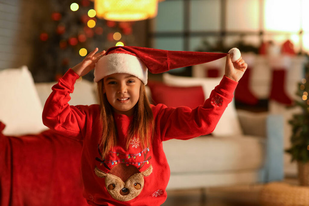 Roztomilé holčička v santa klobouk doma na Štědrý večer - Fotografie, Obrázek