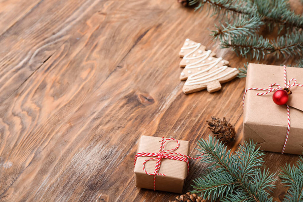 Vánoční strom větve s dárkovými krabicemi a sušenky na dřevěném pozadí - Fotografie, Obrázek