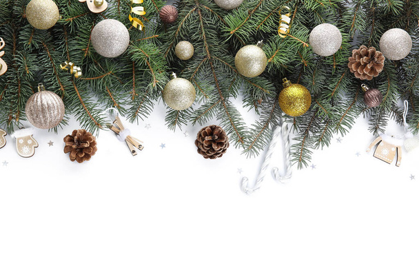 Fir takken met kleurrijke kerstballen en kegels op witte achtergrond - Foto, afbeelding