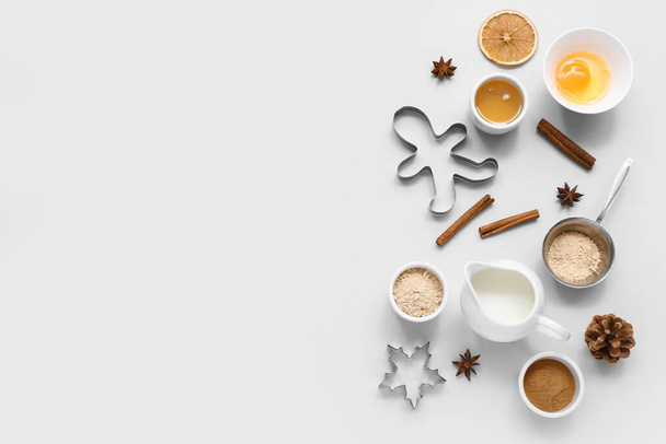 Composition with ingredients for preparing tasty Christmas cookies and cutters on grey background - Photo, Image