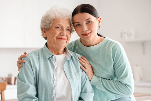 Senior woman with her daughter hugging in kitchen - Photo, Image