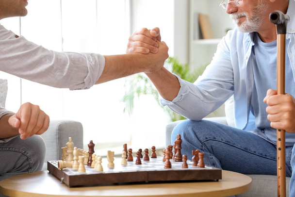 Senior homme avec son fils jouant aux échecs à la maison, gros plan - Photo, image