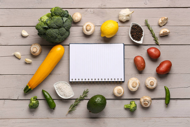 Üres notebook friss zöldségekkel fehér fa asztalon - Fotó, kép