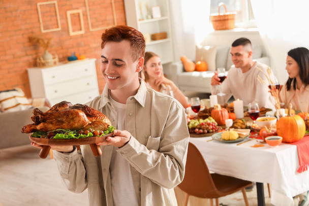 Jeune homme avec dinde dînant le jour de Thanksgiving - Photo, image