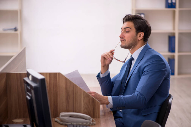 Молодий працівник бізнесмена сидить на робочому місці
 - Фото, зображення