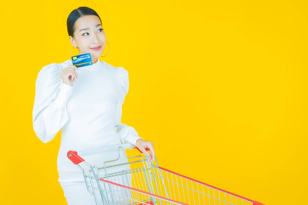 Portret piękna młoda azjatycka kobieta uśmiech z koszyka spożywczego z supermarketu na tle koloru - Zdjęcie, obraz