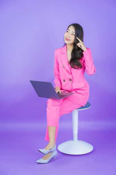 Retrato hermosa joven mujer asiática sonrisa con ordenador portátil sobre fondo aislado - Foto, Imagen