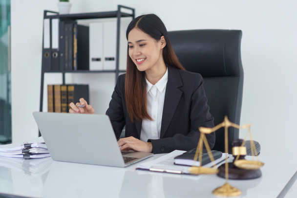 Rechtsanwältin liest Geschäftsvertrag und überprüft rechtliche Vereinbarung auf Laptop in Anwaltsbüro. - Foto, Bild
