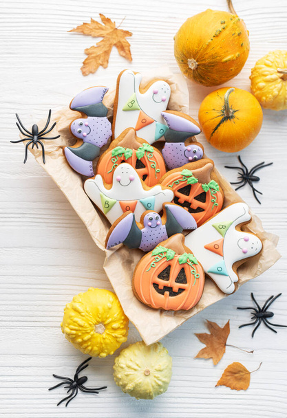 Multicolore Halloween biscotti fatti in casa in una scatola regalo su sfondo di legno bianco. - Foto, immagini