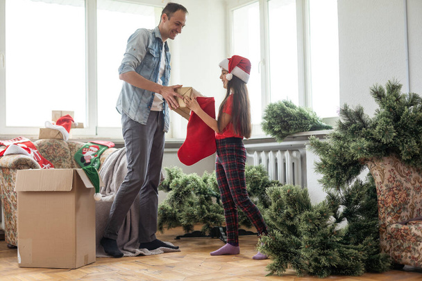 Baba ve kızı Noel ağacını birleştiriyor, gülümsüyor - Noel, tatil, kış konsepti, aile aktivitesi - Fotoğraf, Görsel