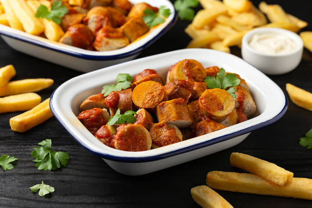 Traditional German currywurst, served with potato chips and sauce. - Photo, Image