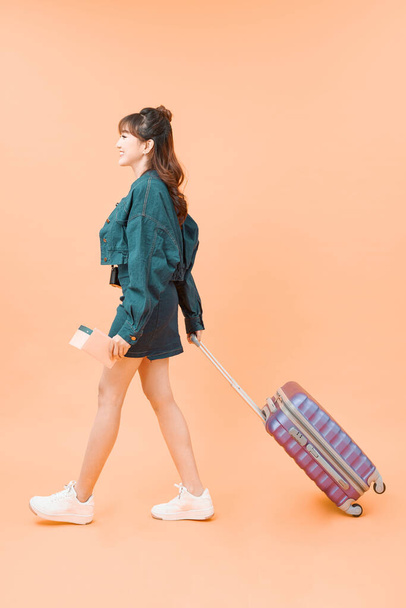 Dívka s kufrem bude cestovat na barevném pozadí - Fotografie, Obrázek