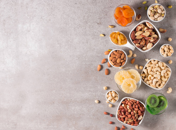 Healthy mix nuts and dried fruits on wooden background. Almonds, hazelnuts, cashews, peanuts, pistachios, Brazilian nuts - Photo, Image