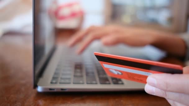 サイドビュー。 オンラインでクレジットカードで購入する若い女性の手. ラップトップを使用して自宅でオンライン取引を行う女性. - 映像、動画