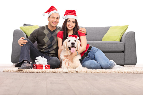 Couple in Santa hats with dog - Photo, image