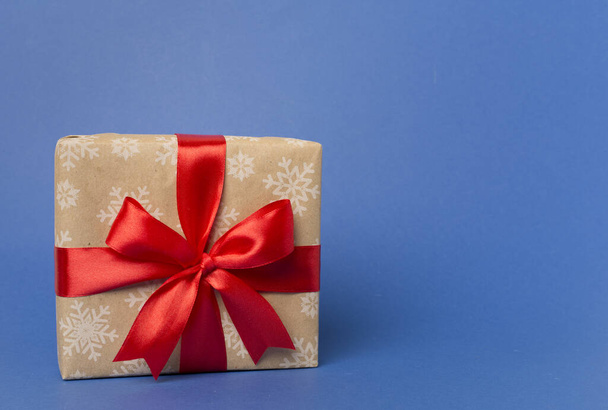 Caja de regalo con lazo de cinta roja sobre fondo de color. - Foto, imagen