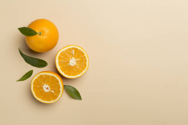 新鮮なオレンジと色の背景に葉でフラットレイアウト. - 写真・画像