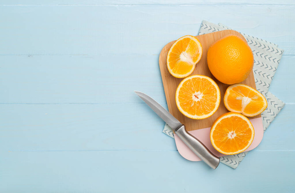 Flat lay with fresh oranges and leaves on wooden background. - Fotó, kép