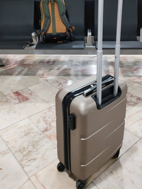 Μοναχική βαλίτσα και ένα σακίδιο μόνο στα καθίσματα ενός τερματικού σταθμού αεροδρομίου - Φωτογραφία, εικόνα