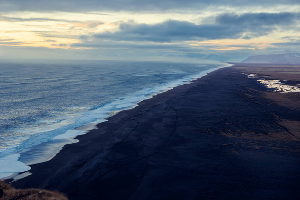 Északi partvonal fekete homokos stranddal, kiváló kilátás nyílik a vadonra, hullámok összeomlanak. Fagyasztott paradicsom Izlandon csodálatos strandok sziklák és vizek, út menti. - Fotó, kép