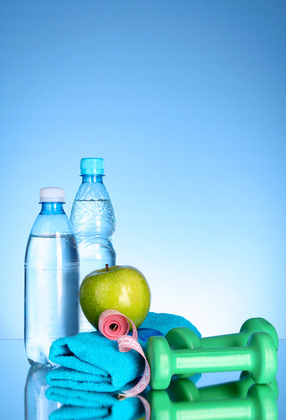 Blue bottle of water, apple, sports towel,dumbbells and measure - Foto, Imagem