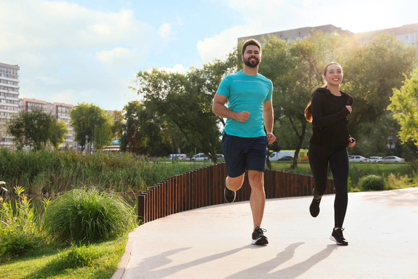 Healthy lifestyle. Happy couple running outdoors, space for text - Foto, imagen