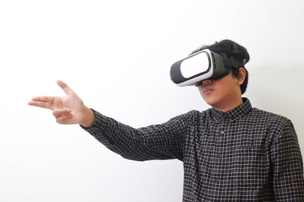 Retrato de hombre asiático en camisa a cuadros negro usando gafas de Realidad Virtual (VR) y saludar a su amigo dentro del juego con la palma abierta. Imagen aislada sobre fondo blanco - Foto, imagen