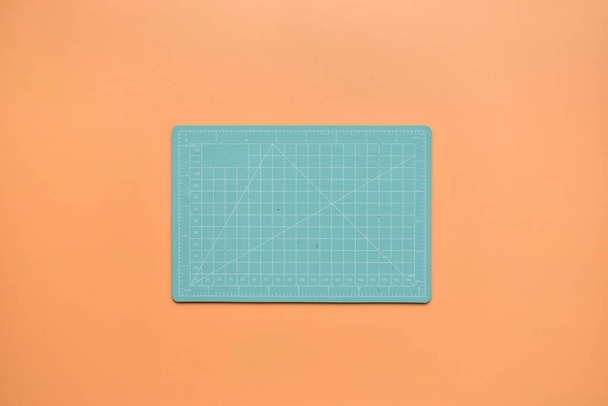 tapete de corte verde no fundo laranja, ferramenta de objeto para design  - Foto, Imagem