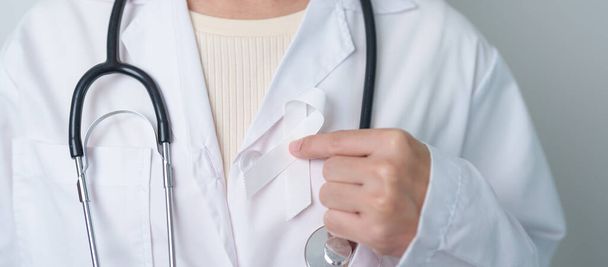 November Lungenkrebs-Aufklärungsmonat. Arzt mit weißem Band im Krankenhaus. Gesundheitswesen und Weltkrebstag - Foto, Bild