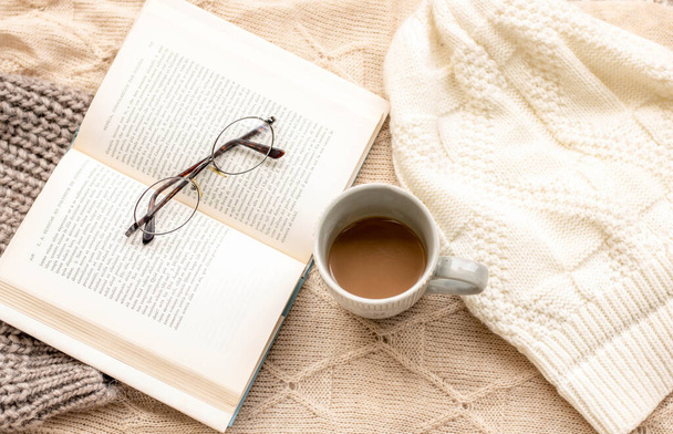 suéteres acogedores con una taza de café y un libro - Foto, imagen