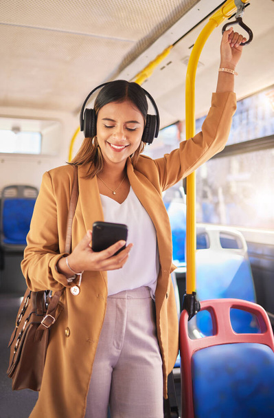 笑顔,携帯電話,ヘッドフォンでバスに乗っている女性は,都市の通勤やストリーミングポッドキャストを運転します. 公共交通機関,サービス,幸せな女の子は携帯電話でラジオを聞いています. - 写真・画像